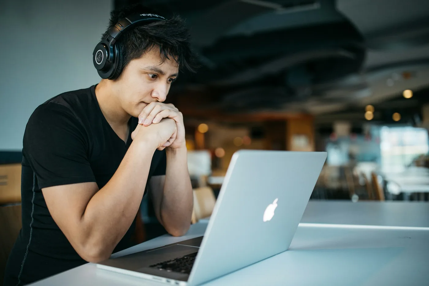 Personne suivant un cours en ligne au casque devant un ordinateur portable